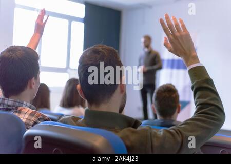 Education process at professor`s lecture in audience. Young male teacher giving presentation for students in a lecture hall Stock Photo
